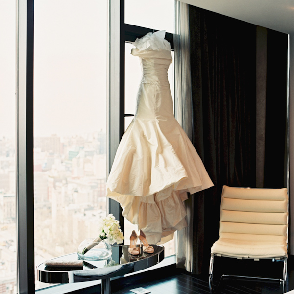 photo by New York City based wedding photographer Karen Hill - beautiful ivory mermaid style wedding gown hanging in front of window 